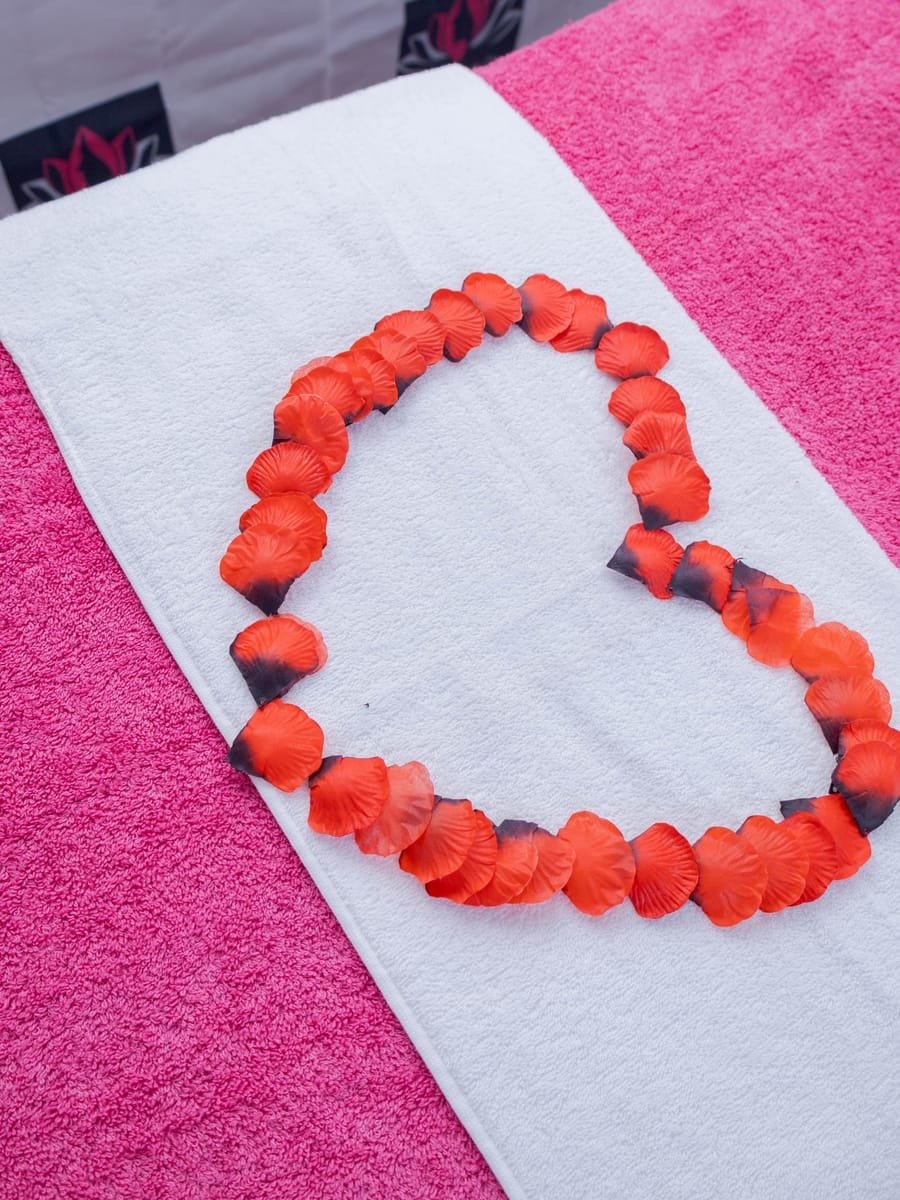 Massage bed set with rose petals for a couples treatment